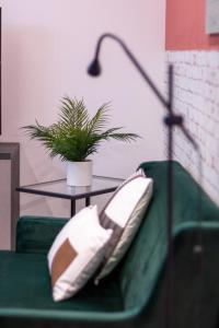 博洛尼亚Tartini Lofts的一张带桌子和盆栽植物的绿色沙发
