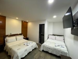 波哥大Hotel Yolima Real的酒店客房,配有两张带白色床单的床