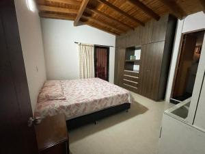 贝约Amplio apartamento en Niquia的一间卧室配有一张床和一个木制橱柜