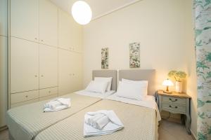 KhelmátaRania Apartments Helmata的白色卧室配有两张带毛巾的床
