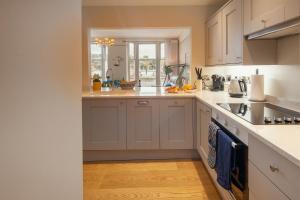 达特茅斯Harbour Living的厨房配有白色橱柜和水槽