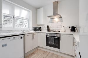 利物浦Hornsey Lodge - Anfield Apartments的白色的厨房设有水槽和炉灶。