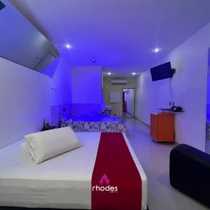 卡鲁阿鲁Rhodes Hotel Caruaru的一间卧室配有一张紫色照明的大床