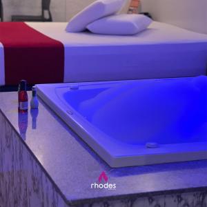 卡鲁阿鲁Rhodes Hotel Caruaru的蓝色浴缸位于两张床旁边