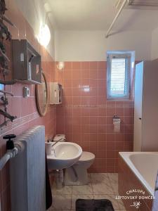 利普托斯基米库拉斯Chalupa Liptovský domček的粉红色的浴室设有水槽和卫生间
