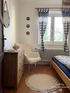利普托斯基米库拉斯Chalupa Liptovský domček的一间卧室配有一张床、一个梳妆台和一扇窗户。