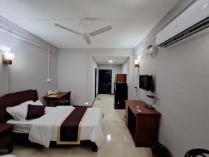 艾藻尔Hotel Chhungte International的酒店客房,配有床和电视