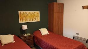 卡塔马卡La Pirca Rosada的一间卧室设有两张床,墙上挂着一幅画