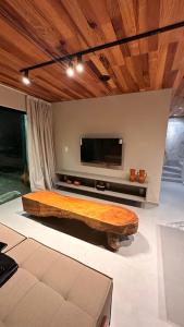 皮亚萨布苏Vila Piá的客厅设有一张大型木床,配有电视