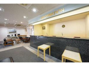 北上市Green Hotel Kitakami - Vacation STAY 09848v的一间设有桌子的等候室和一个带冒险标志的柜台