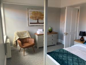 约维尔Stylish Flat in Yeovil Somerset的一间卧室配有一张床、一把椅子和一张书桌