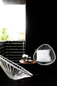 恩西尼塔斯Twelve Senses Retreat, a Member of Design Hotels的阳台的白色椅子和桌子