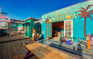 圣地亚哥圣地亚哥ITH海滩简易别墅冲浪旅舍的站在五彩缤纷的建筑前的妇女