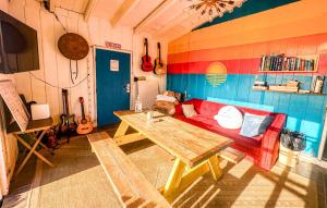 圣地亚哥圣地亚哥ITH海滩简易别墅冲浪旅舍的客厅配有红色的沙发和桌子