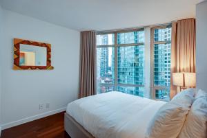 温哥华杜诺文酒店的一间卧室设有一张床和一个大窗户