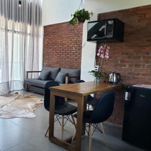 Balneário GaivotasThe Guest House hostel的客厅配有木桌和椅子
