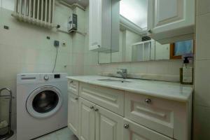 伊斯坦布尔Bakirkoyde essiz harika konumda的厨房配有水槽和洗衣机