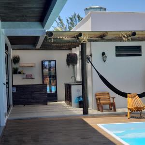 Balneário GaivotasThe Guest House hostel的一个带吊床的庭院和一个游泳池