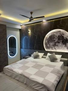 勒克瑙Grand DLF Stays的一间卧室配有一张大床和月亮壁画