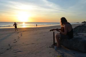 波波约Castaways Nicaragua的日落时在海滩上玩板球的女人