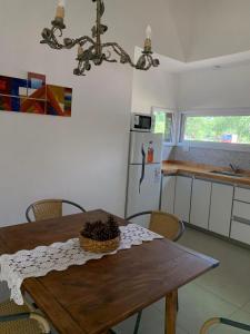 梅洛Casa Aguaribay para 4 personas, cerca del centro, Merlo San Luis的厨房配有木桌、椅子和冰箱