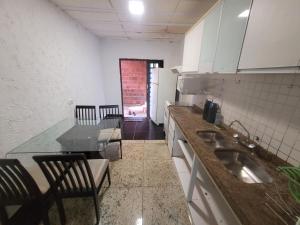 巴西利亚Casa Cmc011 Simples e Objetiva Com Estacionamento的厨房配有水槽和桌椅