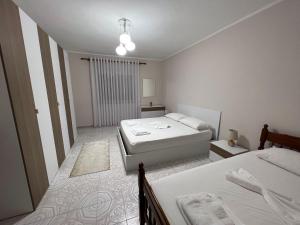 斯库台Home Shkodra Center的一间白色卧室,配有两张床和窗户