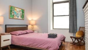 纽约3BR Central Park的卧室配有粉红色的床、椅子和窗户