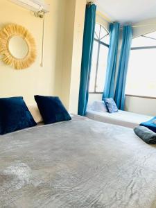 曼塔Reef Hostel Manta的一间卧室配有一张带蓝色窗帘和镜子的床
