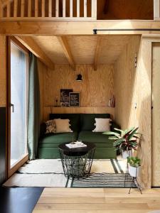 斯普里蒙Bayda's Tiny House的客厅配有绿色沙发和桌子