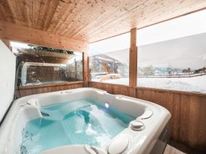 KleinbodenAlpenLuxus' MOUNTAIN SUITE in the SportLodge with natural pool, whirlpool & sauna的一个带窗户的客房内的按摩浴缸