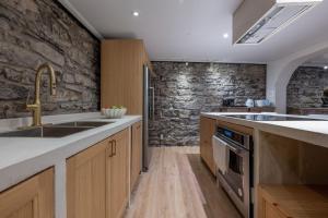 蒙特利尔Exclusive 6 bed, 6 bath residence in Old Montreal的一个带水槽和石墙的厨房