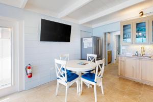 基克罗尼海滩The Fisherman's Cottage的一间配备有白色桌椅的用餐室