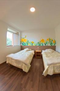 帕查卡马克Casa Boutique QX- Pachacamac的墙上画画的房间里设有两张床