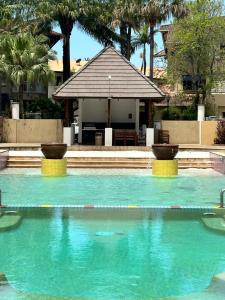 Cairns NorthLuxury tropical 2bedroom apartment in resort 4 swimming pools的一座房子前面的蓝色海水游泳池