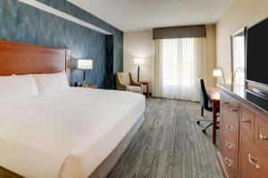 威斯敏斯特Drury Plaza Hotel Denver Westminster的酒店客房设有一张大床和一张书桌。