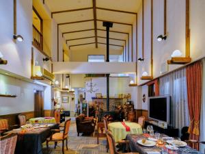 白马村索亚卡兹酒店 的餐厅设有桌椅和平面电视。