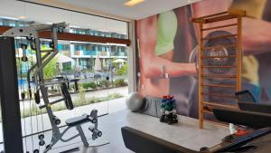 伊波茹卡Flat Studio aconchegante com vista para piscina.的健身房设有大窗户 。