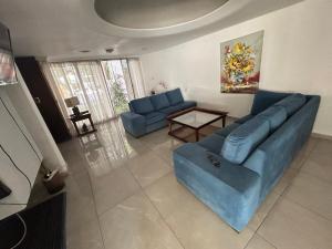门多萨Casa Barrio Bombal的客厅配有蓝色的沙发和桌子