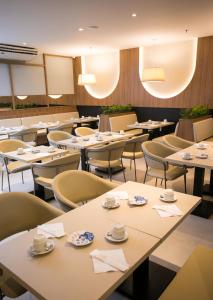里约热内卢Regency Park Hotel - SOFT OPENING的用餐室配有桌椅和杯子