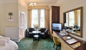 伯恩茅斯Cavendish Central Bournemouth的酒店客房配有书桌和镜子
