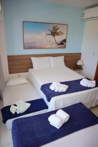 伊波茹卡Flat Studio aconchegante com vista para piscina.的两张位于酒店客房的床,配有毛巾