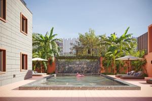 罗安达Protea Hotel by Marriott Luanda的在庭院游泳池游泳的人