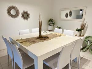 埃斯特角城APARTAMENTO A METROS DEL MAR, ALQUILER TEMPORADA - 3 Dormitorios en Forest 1的白色的用餐室配有白色的桌椅