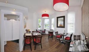 伯恩茅斯Cavendish Central Bournemouth的用餐室设有桌椅和窗户。