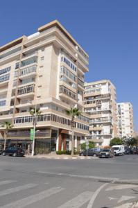 阿加迪尔Appartement 5 etoiles agadir vue mer的停车场内停放汽车的大型建筑