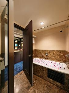 莎阿南Mardhiyyah Hotel and Suites的一间带浴缸和大镜子的浴室