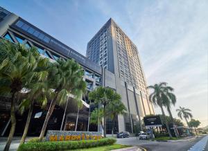 莎阿南Mardhiyyah Hotel and Suites的一座高大的建筑,前面有棕榈树