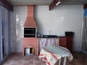 蒙加瓜Casa de Praia com Piscina em Mongagua - Disponivel Carnaval的一间玩具厨房,里面配有砖炉