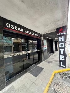 图巴朗Oscar Palace Hotel - SOB NOVA GESTÃO的商店前方有标牌读奥斯卡宫酒店